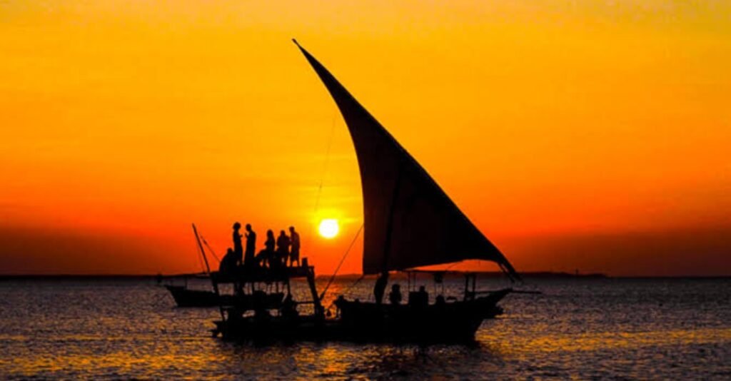 Dhow Boat Sunset Cruise Zanzibar with a traditional wooden dhow sailing across the Indian Ocean during a spectacular sunset.